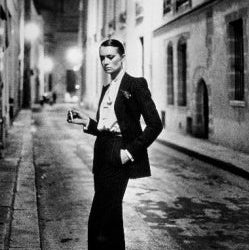 Rue Aubriot Person in a formal outfit standing on a city street at night.