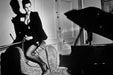 Alt Tag: Helmut Newton Saddle II Paris 1976 vintage silver gelatin print fashion photograph of model posed on sofa beside piano